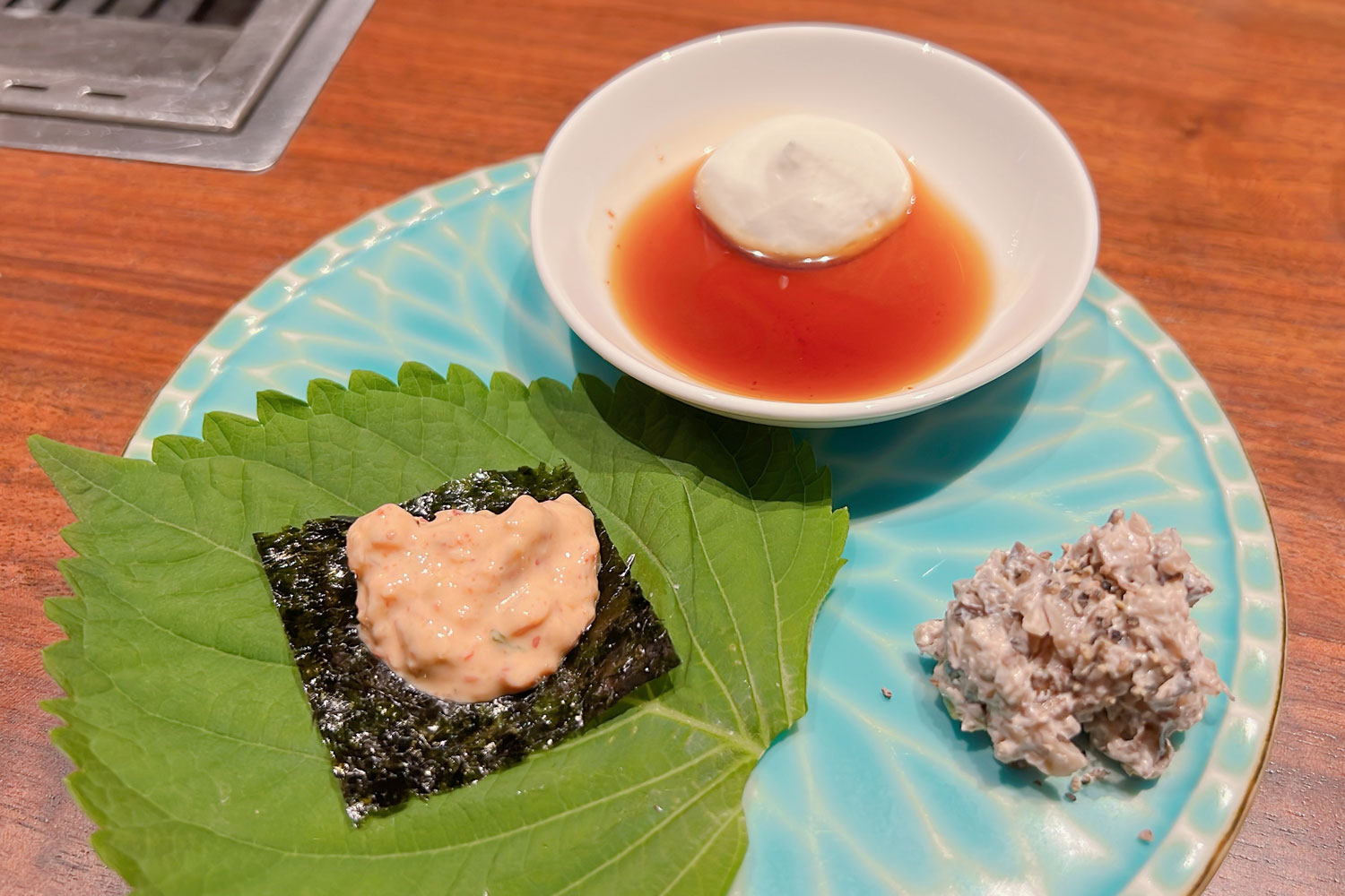 白い小皿の「ホイップヨーグルトと甘たれのソース」、右下の「キノコとヨーグルトのソース」、えごまの葉にのる「キムチヨーグルトサムギョプサルスタイル」の３種類。