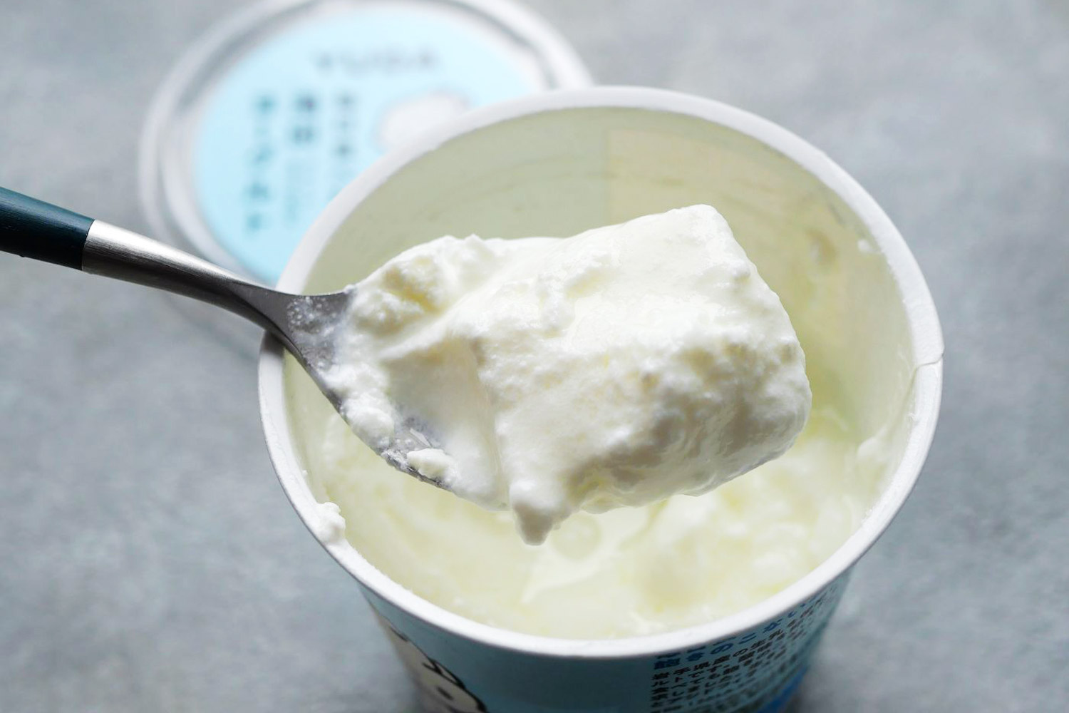 開けてみると、表面にうっすら乳清がういている。生乳100％ヨーグルトは、とろとろとして固まりにくいという認識があったが、スプーンですくってみると、ふるふると軟らかく固まっていた。