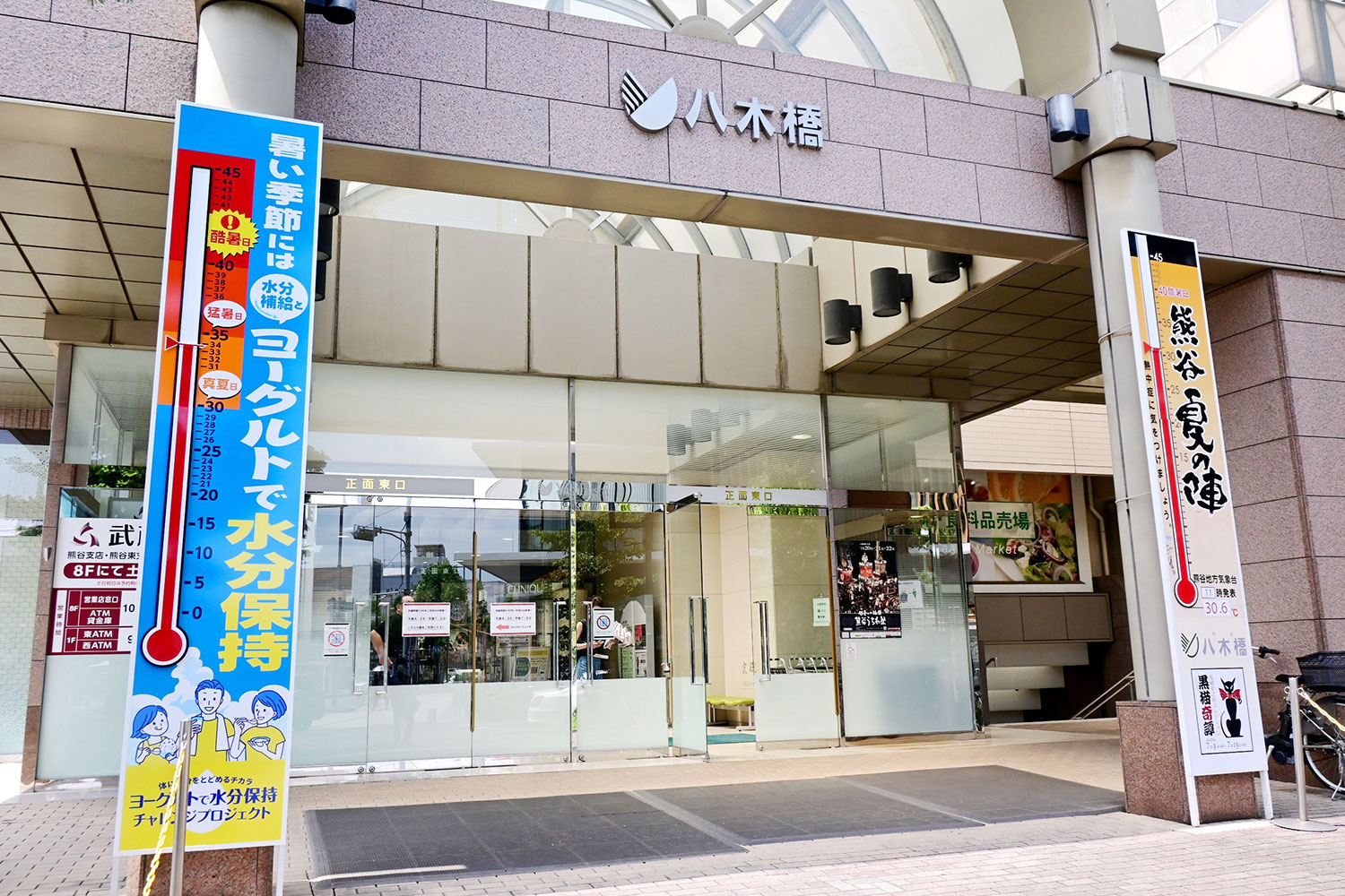 今季は「ヨーグルトで水分保持 チャレンジプロジェクト」デザインの大温度計（左）も登場。この日は13時の段階で34℃の暑さに